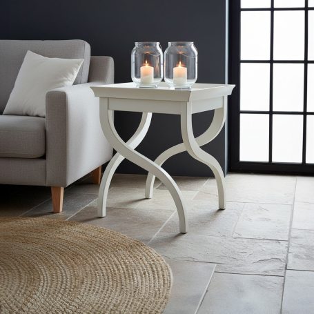 PR-2263 Weißer Beistelltisch mit geschwungenen Beinen, zwei Glaskerzen und Teppich.