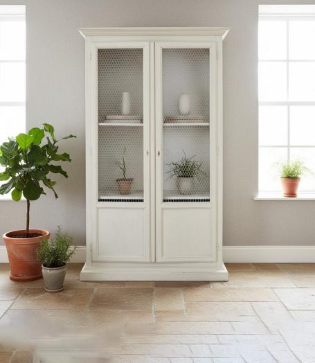 Heller, weißer Vitrinenschrank mit Pflanzen in Töpfen und Fenstern im Hintergrund.