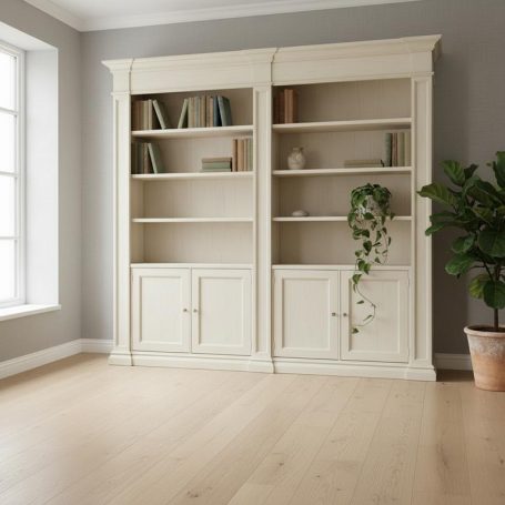 Helle, moderne Wohnräume mit weißem Bücherregal und einer Pflanze in der Ecke.