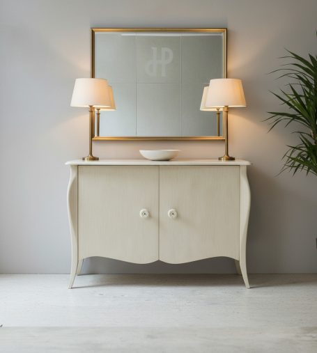 Weißes Sideboard mit geschwungenen Beinen, zwei Lampen und Spiegel darüber.