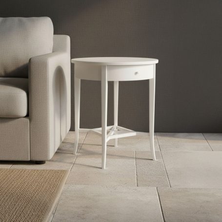 PR-1960 Ein runder, weißer Beistelltisch steht neben einem hellen Sofa in einem modernen Raum.