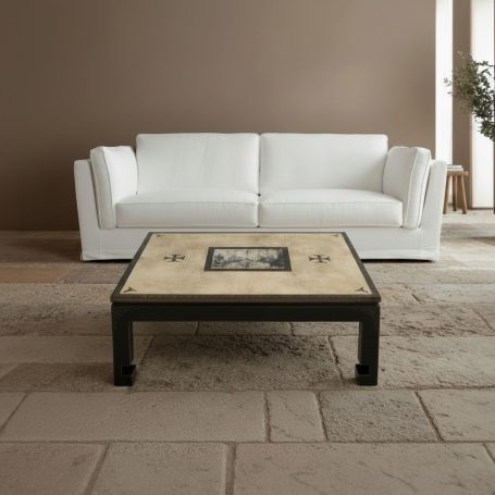 Helles Wohnzimmer mit weißem Sofa und quadratischem Tisch auf einem Teppich.