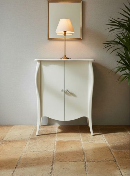 Weißer, geschwungener Wohnzimmerschrank mit Lampe und Spiegel an einer Wand.