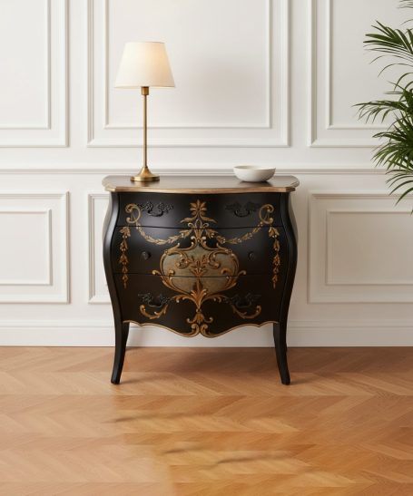 Schwarzer, eleganter Kommode mit goldenen Verzierungen und einer Lampe darauf.