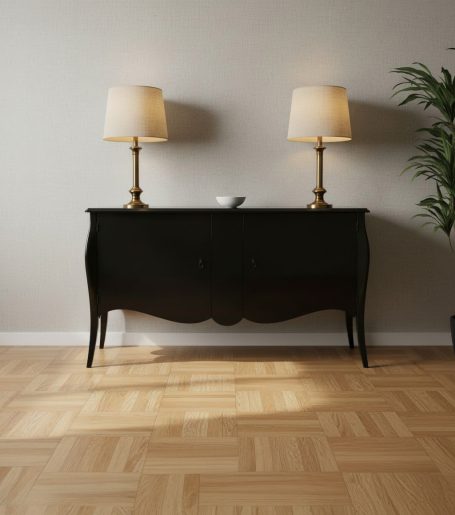Schwarzer Sideboard mit zwei Lampen und einer kleinen Schale, daneben eine Pflanze.