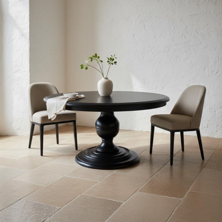 PR-4072 Runder Tisch mit schwarzem Fuß, umgeben von zwei beigen Stühlen und einer Vase mit Pflanzen.