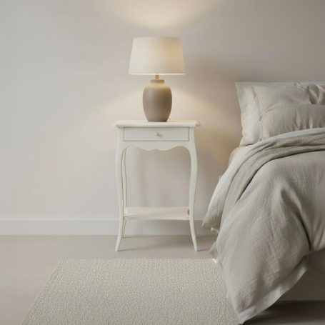 PR-3863 Nachttisch mit Lampe neben einem Bett in einem hellen, minimalistischen Schlafzimmer.